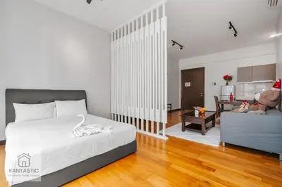 a bedroom with a bed and a living room at Regalia Residence by FANTASTIC in Kuala Lumpur
