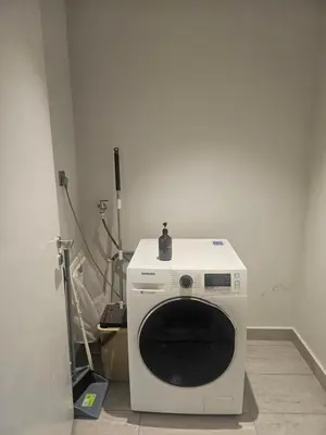 a white washing machine sitting in a room at Anggun Residences Serviced Suites in Kuala Lumpur