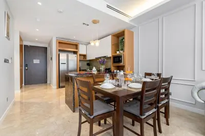 a kitchen and dining room with a wooden table and chairs at Anggun Residences Serviced Suites in Kuala Lumpur