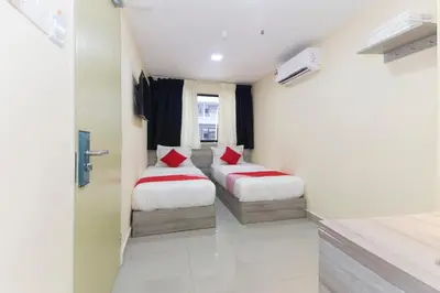 two beds in a small room with a window at Hotel O Kl Centre Point in Kuala Lumpur