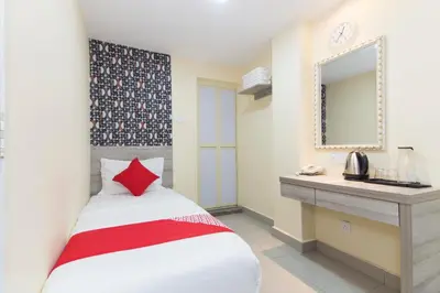 a bedroom with a bed and a sink and a mirror at Hotel O Kl Centre Point in Kuala Lumpur