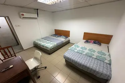 two beds in a room with a desk and a chair at Sha La La Hostel in Kuala Lumpur