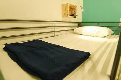 a bed with a black blanket on top of it at Sha La La Hostel in Kuala Lumpur
