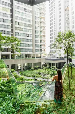 a woman standing in a garden with tall buildings at Regalia Upper View Hotel in Kuala Lumpur