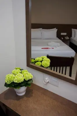 a mirror in a room with a bed and flowers at My Hotel @ Sentral in Kuala Lumpur
