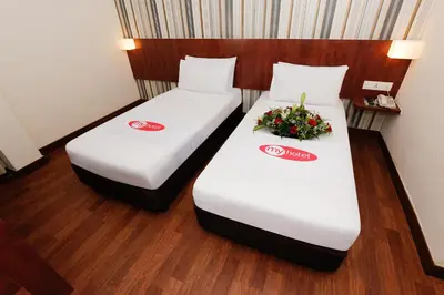two beds in a hotel room with flowers on them at My Hotel @ KL Sentral in Kuala Lumpur