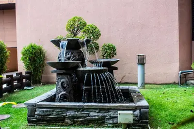 a fountain in the grass in a yard at The Apartments at Times Square KL by Robinsons in Kuala Lumpur