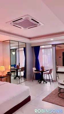 a bedroom with a bed and tables and chairs at The Apartments at Times Square KL by Robinsons in Kuala Lumpur