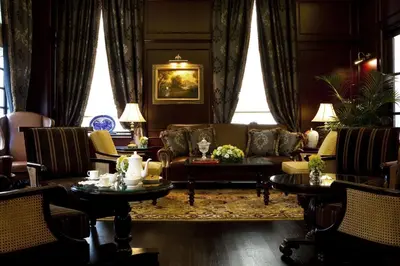 a living room with a couch and chairs and tables at The Majestic Hotel Kuala Lumpur, Autograph Collection in Kuala Lumpur