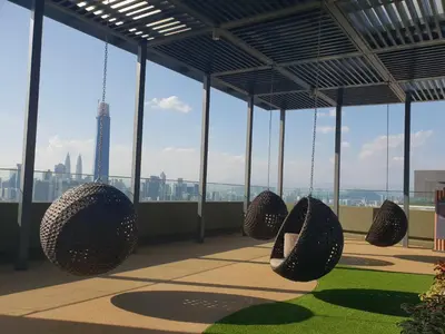 a building with hanging chairs with a view of the eiffel tower at Sunway Velocity V Residence Suites in Kuala Lumpur