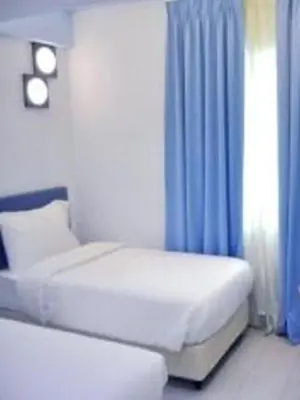 a bedroom with a bed and a blue curtain at YY318 Hotel Bukit Bintang in Kuala Lumpur