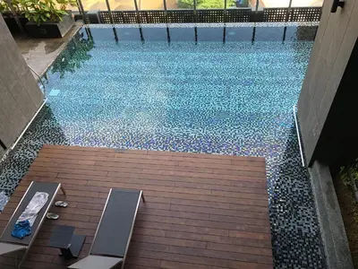 an overhead view of a swimming pool with a wooden deck at Modern 3BR with Iconic KLCC Towers Skyline Views and Parking in Kuala Lumpur