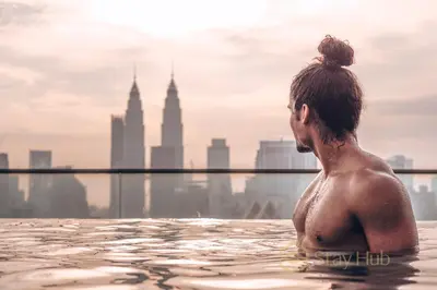 a woman in a infinity pool with a view of the city at Regalia Residence The Sky Pool Suite in Kuala Lumpur