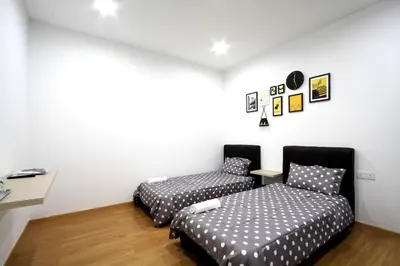 two beds in a room with white walls and wooden floors at Zeta Desky in Kuala Lumpur