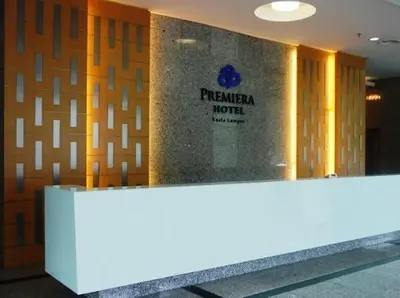 a hotel lobby with a reception desk in front of a wall at Premiera Hotel Kuala Lumpur in Kuala Lumpur