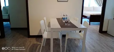 a white dining room table with chairs and glasses on it at KL Times Square Apartment in Kuala Lumpur