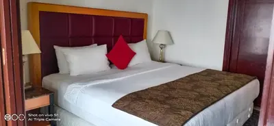a bedroom with a large bed with two red pillows at KL Times Square Apartment in Kuala Lumpur