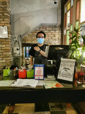 a person wearing a mask standing behind a counter at Mingle Highstreet - CoWorking Hub in Kuala Lumpur