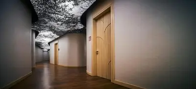 a hallway with a row of doors with a painting on the wall at EQ Kuala Lumpur in Kuala Lumpur