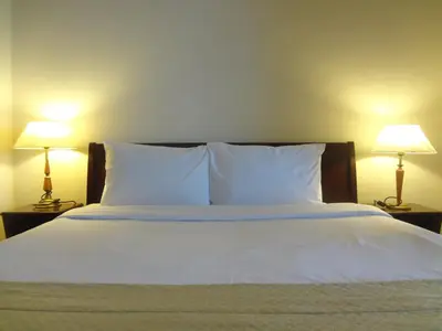 a bed with white pillows and two lamps on tables at Better Residence Suite at Times Square Bukit bintang kl in Kuala Lumpur
