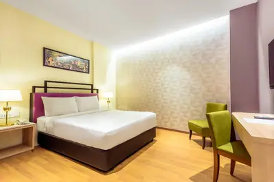 a hotel room with a bed and a desk at MPalace Hotel KL in Kuala Lumpur