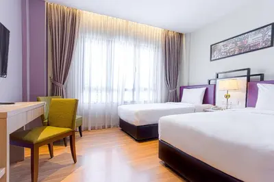 a hotel room with two beds and a desk at MPalace Hotel KL in Kuala Lumpur
