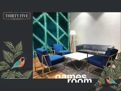a living room with blue chairs and a table at KL Gateway Premium Residence - Easy LRT Access in Kuala Lumpur
