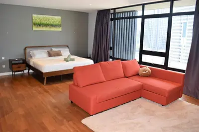 a living room with a couch and a bed at Anggun Residences Luxe in Kuala Lumpur