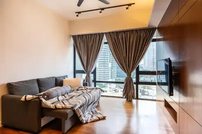 a living room with a couch and a large window at Anggun Residences Luxe in Kuala Lumpur