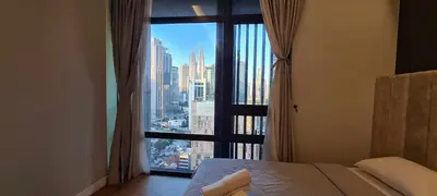 a bedroom with a large window with a view of a city at Anggun Residences Luxe in Kuala Lumpur
