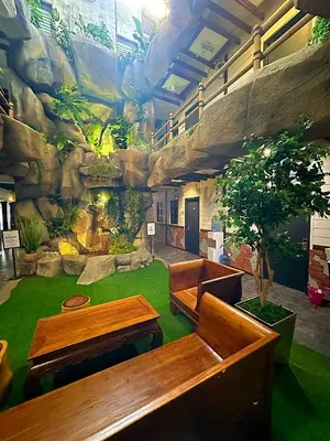 a lobby with benches and a mural of a mountain at D'Garden Hotel Kuala Lumpur in Kuala Lumpur