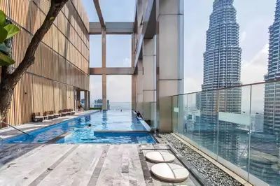 a swimming pool in the middle of a building with tall buildings at Tropicana The Residence KLCC in Kuala Lumpur