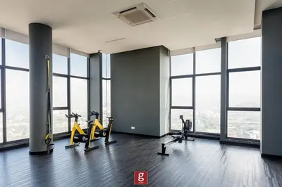 a gym with treadmills and ellipticals in a building with windows at EXPRESSIONZ KLCC by Gsuites in Kuala Lumpur