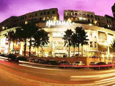 a building with cars parked in front of a street at Dorsett Residences Sri Hartamas KL in Kuala Lumpur