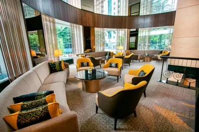 a hotel lobby with couches and chairs and windows at Perdana Kuala Lumpur City Centre in Kuala Lumpur