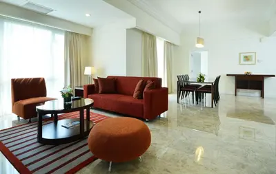 a living room with a red couch and a table at Perdana Kuala Lumpur City Centre in Kuala Lumpur