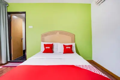 a bed with red pillows in a green room at OYO 89652 Bjorn Boutique Hotel in Kuala Lumpur