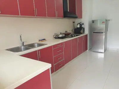 a kitchen with red cabinets and a stainless steel refrigerator at #PERFECT# Location BUKIT BINTANG Apartment in Kuala Lumpur