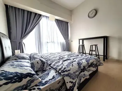 a bedroom with a bed and a clock on the wall at Star Residences KLCC in Kuala Lumpur