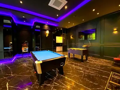 a pool table in a room with purple lights at Star Residences KLCC in Kuala Lumpur