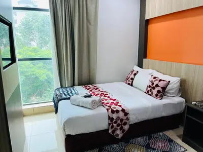 a bedroom with a bed with pillows and a window at Prime Hotel at TRX Tower in Kuala Lumpur