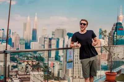 a man standing on the ledge of a city at Penthouse on 34 - The Highest Unit and Best Views in Regalia & Private Rooftop Terrace in Kuala Lumpur