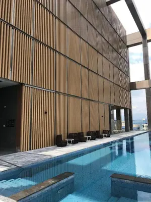 a swimming pool in a building with a wooden wall at Tropicana The Residence, KLCC in Kuala Lumpur