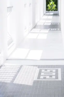 an empty hallway with white tiled floors and doors at Indie Hotel Kuala Lumpur in Kuala Lumpur