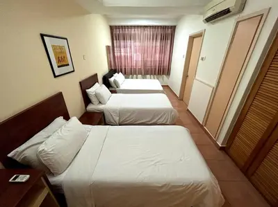 a hotel room with two beds and a table at Pavilion Fahrenheit 88 Bukit Bintang 3 bedrooms in Kuala Lumpur