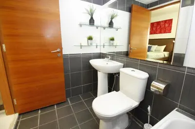 a bathroom with a toilet and a sink and a mirror at UBN by Plush in Kuala Lumpur
