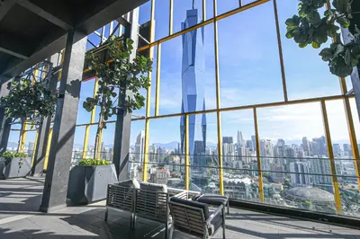 a view of a city from a building with two benches at Opus Residences by Opus Hospitality in Kuala Lumpur