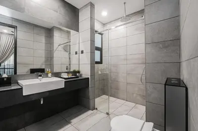 a bathroom with a toilet and a sink and a shower at Opus Residences by Opus Hospitality in Kuala Lumpur