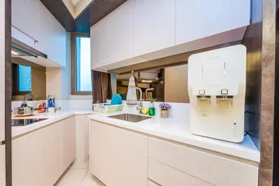 a white kitchen with a sink and a refrigerator at Dorsett Residences Sri Hartamas in Kuala Lumpur