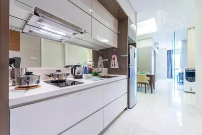 a kitchen with white cabinets and a stove top oven at Dorsett Residences Sri Hartamas in Kuala Lumpur
